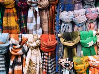 Multicoloured scarfs on a rack at a market stall