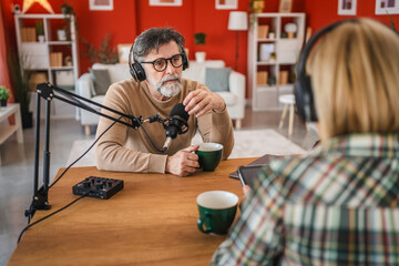 senior man host of podcast ask questions to the woman guest