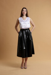 Fototapeta premium Beautiful woman in stylish outfit on beige background