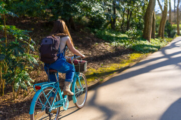 Obraz premium Young woman riding bicycle in a sunny park