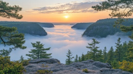 Sunrise over a misty valley, viewed from a rocky outcrop