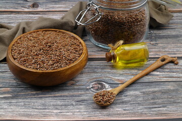 Flax seeds. Flaxseed powder in a wooden spoon. Standing on a Wooden background.