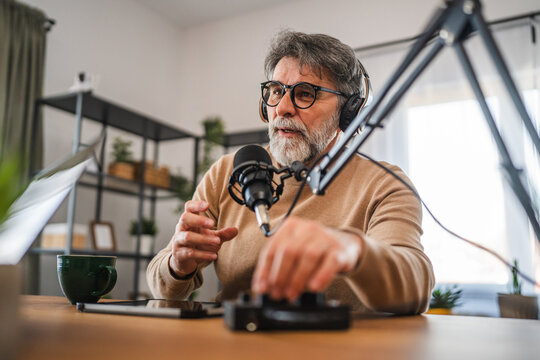 senior man host with headphones set up equipment prepare for podcast