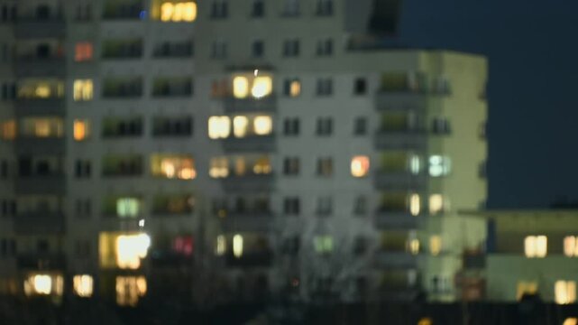 Lights come on in houses in the evening. Out of focus. Timelapse. City life.