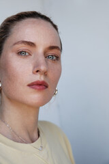 Vertical headshot of caucasian young woman posing over white background looking at the camera.