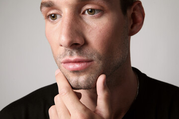 Fototapeta premium Cropped portrait of young handsome man with serious face expression looking away. Mental health.