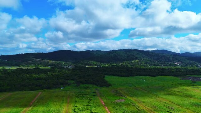 Aerial View of Green Hills and Fields Under a Blue Sky - 4K Drone Footage
