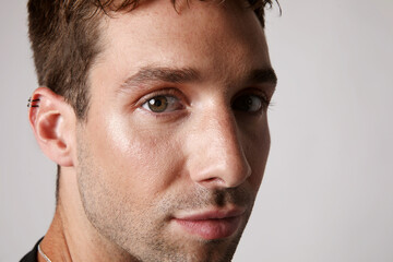 Obraz premium Cropped portrait of young handsome man wearing casual clothing posing over white background. 