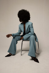 Stunning and young African American woman with afro hair posing over white background. Vertical.