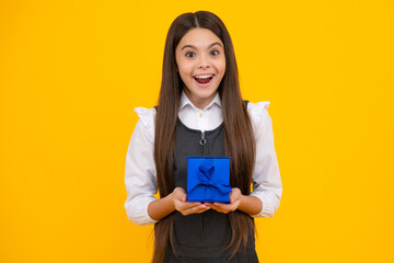 Teenager child girl holding present box isolated over yellow studio background. Present, greeting...
