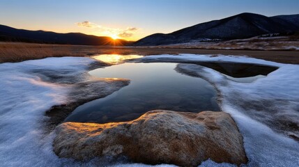 Frozen puddle at sunset, snow-covered landscape