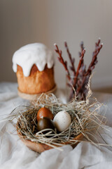Easter table decorated with a homemade Easter cake on a stand, painted eggs and candles, morning...