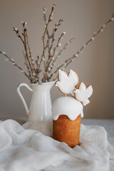 Easter table decorated with a homemade Easter cake on a stand, painted eggs and candles, morning...