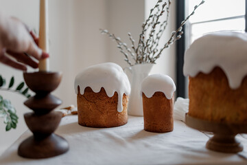 Easter aesthetics, minimalistic background, glazed pastries, candles in the form of Easter eggs, Spring mood of preparation for Easter celebration