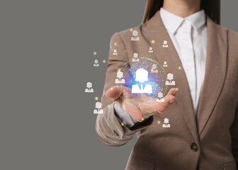 Targeting, recruitment, customer acquisition. Business woman holding virtual globe with human icons against grey background, closeup