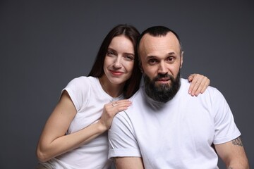 Obraz premium Portrait of happy daughter and father on dark grey background