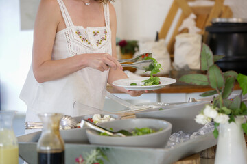 Woman taking food from a buffet line	