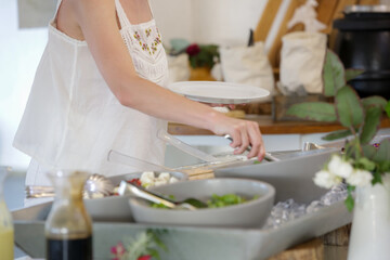 Woman taking food from a buffet line	