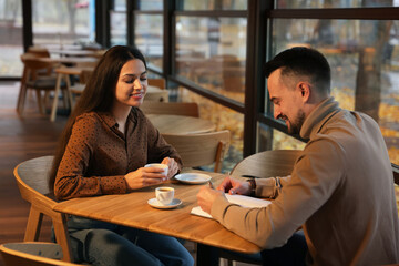 Colleagues working together at table in cafe