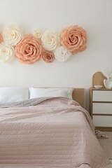 Beautiful decorative paper flowers on wall in bedroom