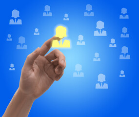 Targeting, recruitment, customer acquisition. Man touching virtual screen with human icons against blue background, closeup