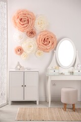 Beautiful decorative paper flowers on wall in room