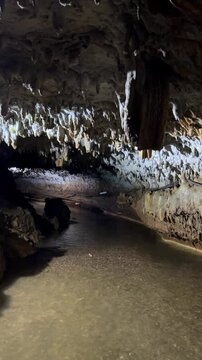 The bright and colorful Abrskil cave. A gallery-type cave in the mountains of Abkhazia with many stalactites and stalagmites, colorful lighting. Otapskaya (Otap cave). 4K