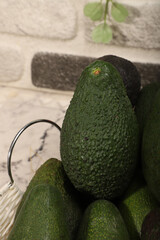 Fresh Ripe Avocados in a Basket with Decorative Greenery