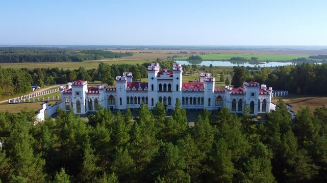 The Puslovsky Palace in Belarus. The Kossovsky Autumn Castle. An old historical castle in the style of English Gothic Revival in Kosovki in sunny autumn weather.Top view.Drone.4K
