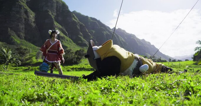 Female fantasy warrior hitting man in panda costume on wires with her weird weapon - low shot