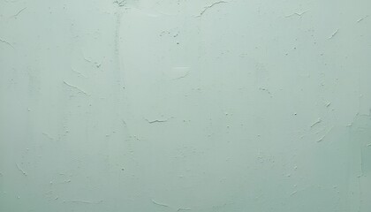 A light green wall with an uneven texture and some cracks and imperfections visible throughout surface