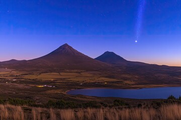 Fototapeta premium A Serene Evening Landscape Majestic Mountains, Tranquil Lake, and a Celestial Glimmer in the Dusk