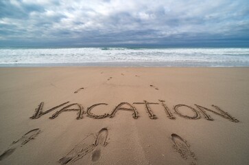 Fototapeta premium Word Vacation Written in the Sand