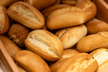 Freshly baked bread rolls in a wooden basket, perfect for breakfast or bakery product marketing, delicious golden crust and soft texture. Mini bread baguettes in basket. pieces to accompany food