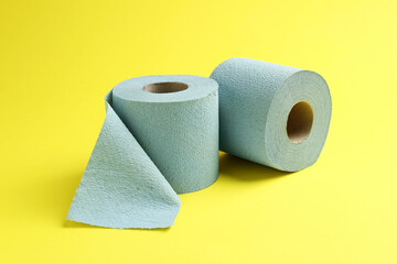 Light blue toilet paper rolls on yellow background