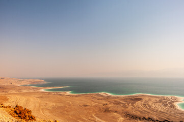 A desert landscape with a blue ocean in the background