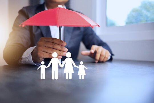 Life insurance concept with businessman using red umbrella to protect the family from health, financial or natural disasters.