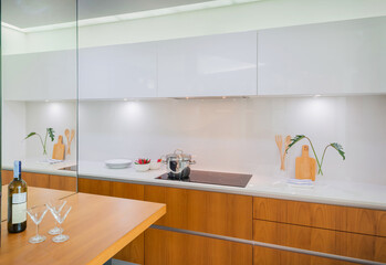 Modern Minimalist Kitchen with Wooden Accents, White Cabinets, and Glass Backsplash, Interior Design