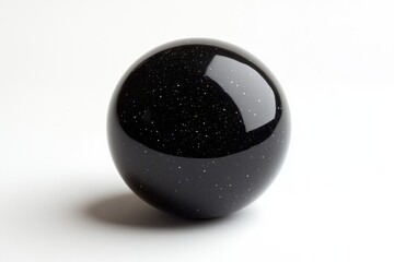 A dark, glossy sphere speckled with iridescent particles, resembling a miniature cosmos.