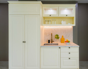 Modern Minimalist Kitchen Design with Cream Cabinetry and Natural Stone Countertop in Bright Interior Space