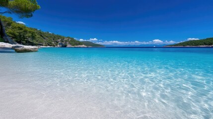 Fototapeta premium Pristine, turquoise water lapping a pristine white-sand beach, backed by lush green hills and a clear blue sky