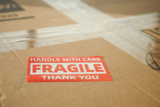 Box labeled fragile handled with care at a shipping facility