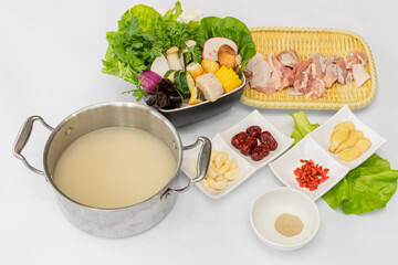 A delicious assortment of chicken hot pot ingredients is beautifully arranged, ready to be simmered in a rich, flavorful broth. Tender cuts of fresh chicken are paired with an array of vegetables