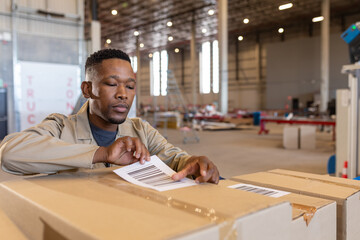Warehouse worker applying barcode labels on boxes, focusing on organization, copy space