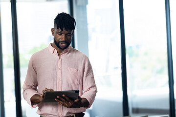 Business professional using tablet in modern office, focusing on digital tasks, copy space