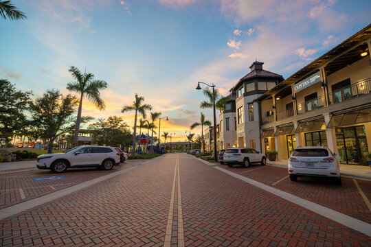 Wellen Park downtown district in North Port, Florida at sunset. Cars drive on main street in walkable city center. North Port, USA - July 23, 2024.