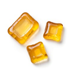 Three Golden Laundry Detergent Pods on White Background