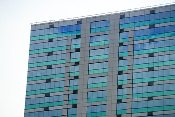Fototapeta premium Modern Glass Building with Reflective Windows and Geometric Design