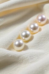 three pearls are arranged in a row on a white cloth