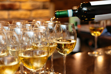 Pouring white wine into elegant glasses.